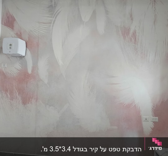 קיר מחופה בטפט דקורטיבי בדוגמת נוצות לבנות על רקע ורוד ואפור
